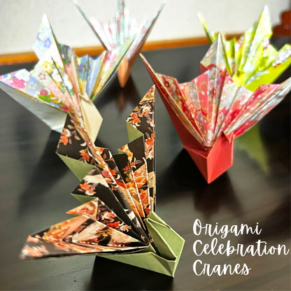 Colorful origami cranes on a dark surface with 'Origami Celebration Cranes' text.
