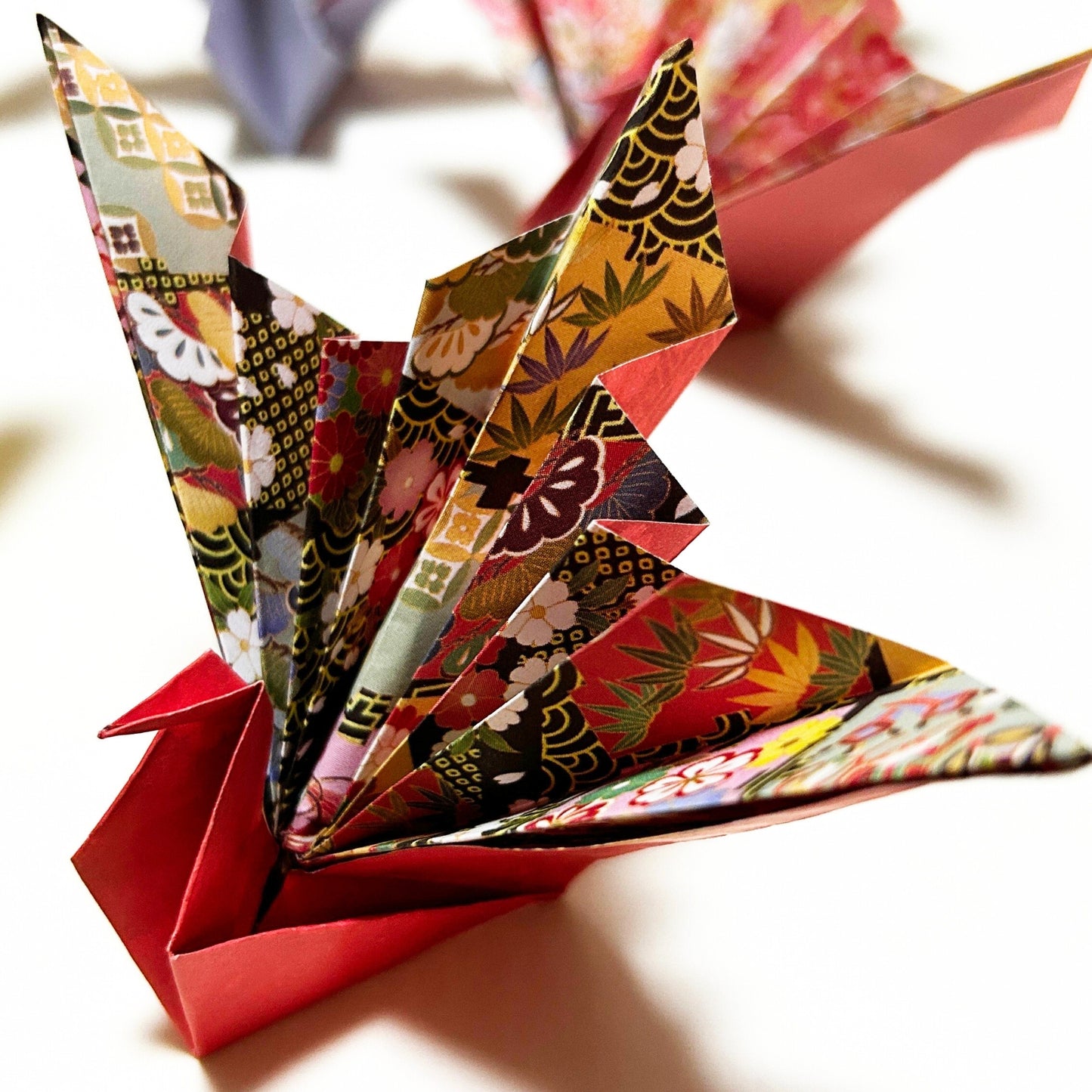 Colorful origami crane with intricate patterns on a light background