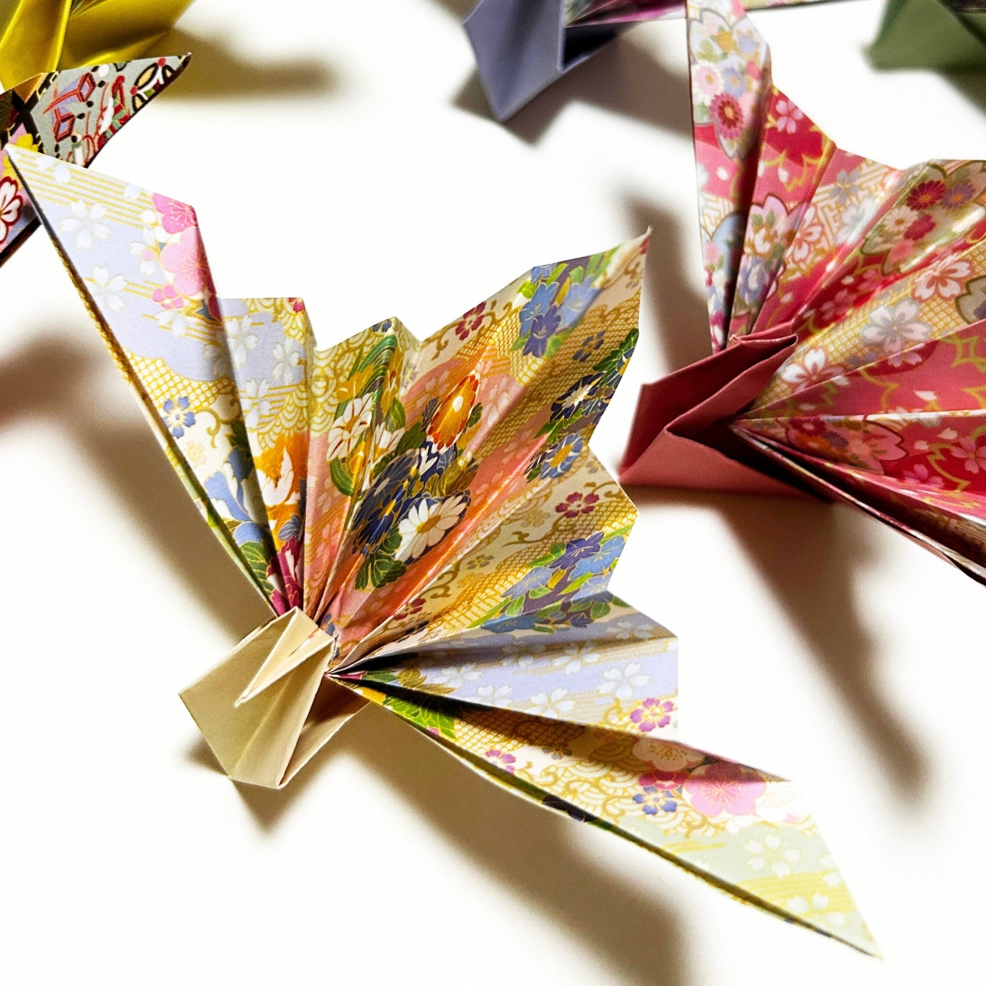 Colorful origami fans on a white surface