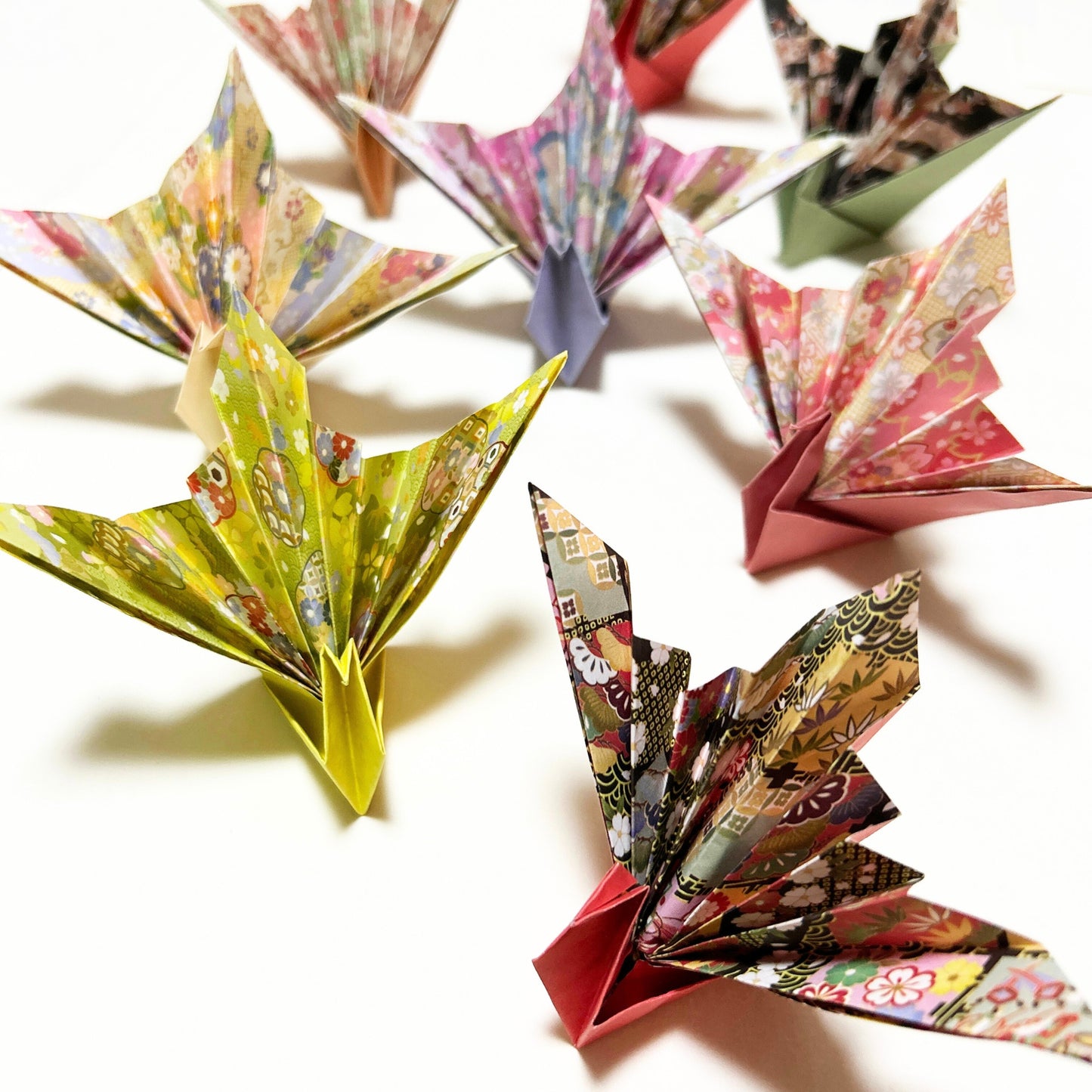 Colorful origami cranes on a white background