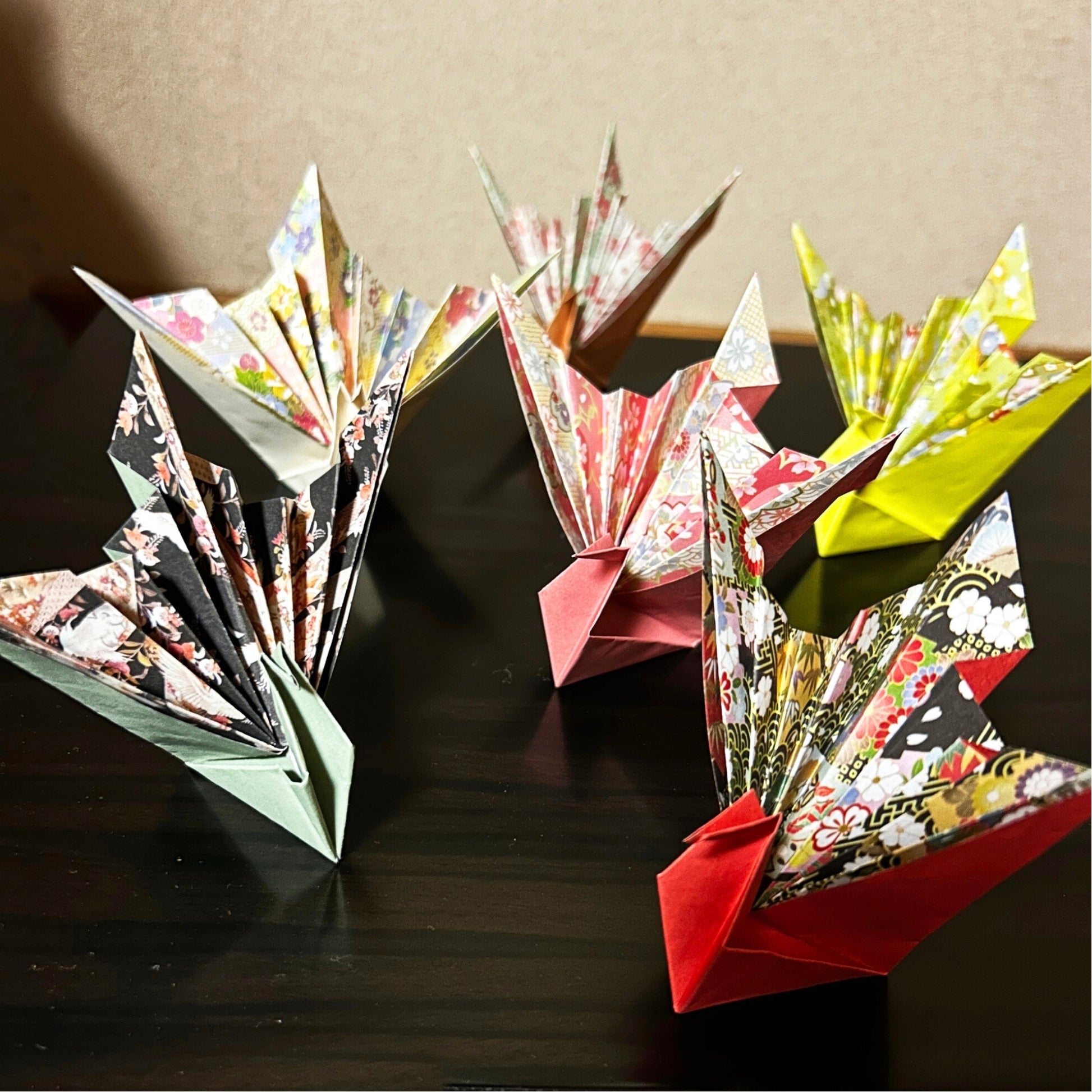 Colorful origami creations on a dark surface with a neutral background