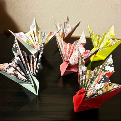 Colorful origami creations on a dark surface with a neutral background