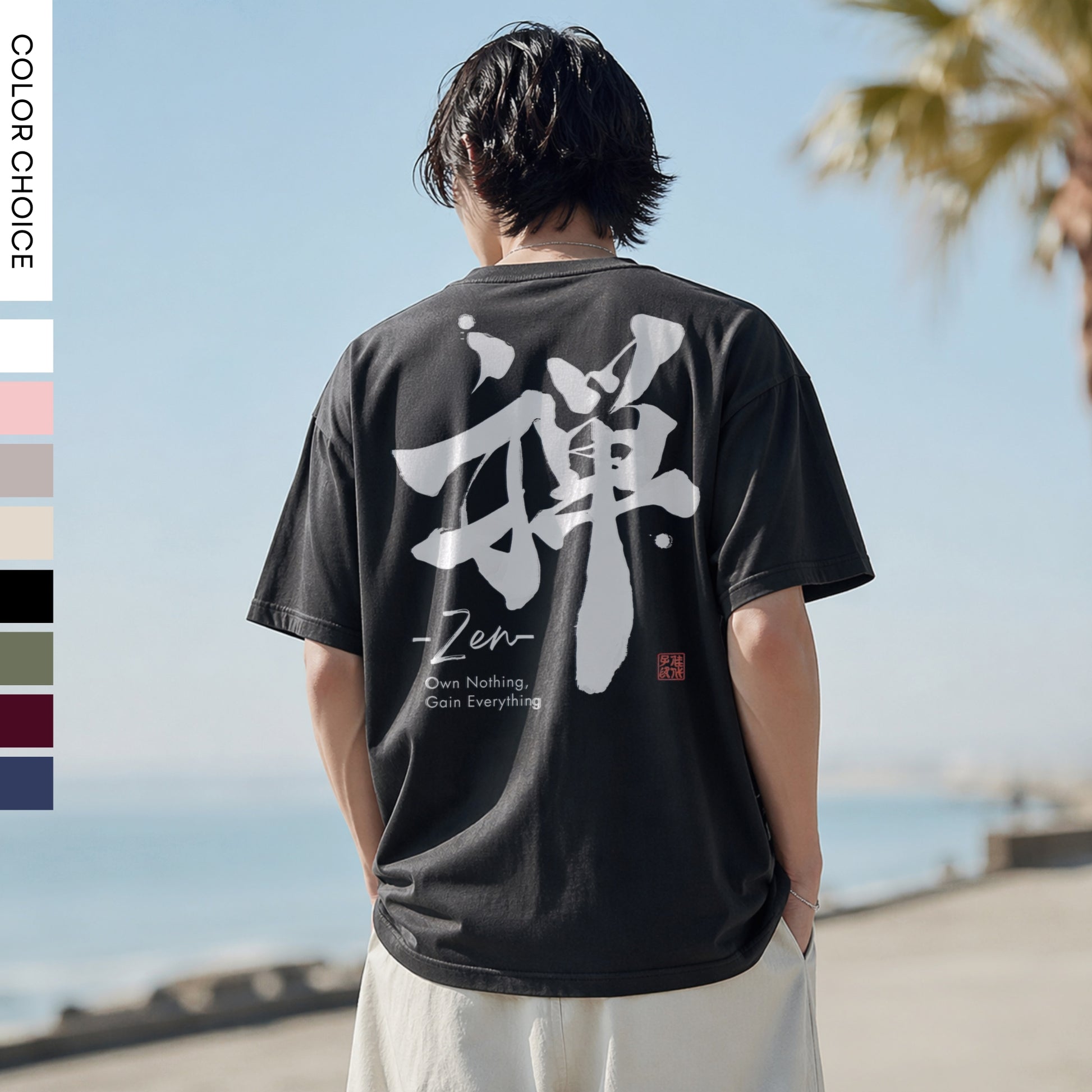 Person wearing a black t-shirt with white text and kanji symbols, standing by a body of water.