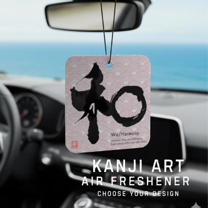 Kanji art air freshener hanging from a car's rearview mirror with a scenic background.