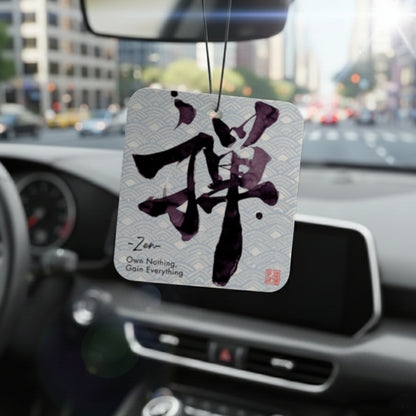 Car air freshener with Zen symbol hanging from a car's rearview mirror.
