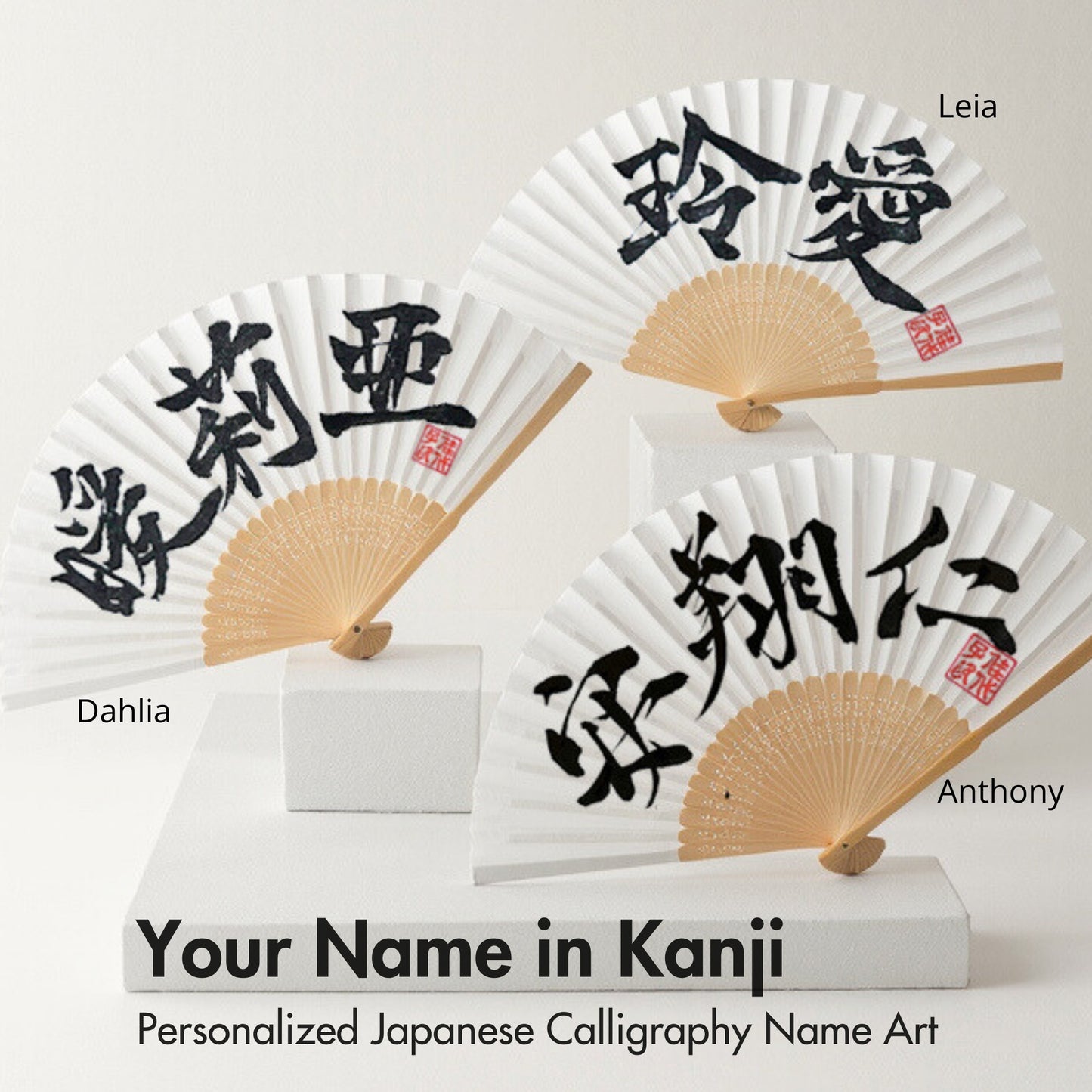 Three Japanese calligraphy fans with personalized names in Kanji on a white background