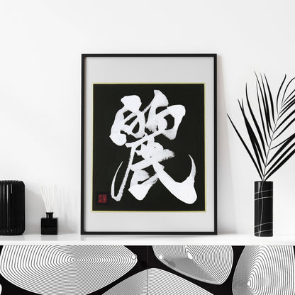 A high-contrast Japanese calligraphy print of 'Rei' (Beautiful/Graceful) on a black background with gold trim, in a black frame. Set in a modern Japandi interior with black vases and diffusers. Perfect wall art for a sophisticated living space.