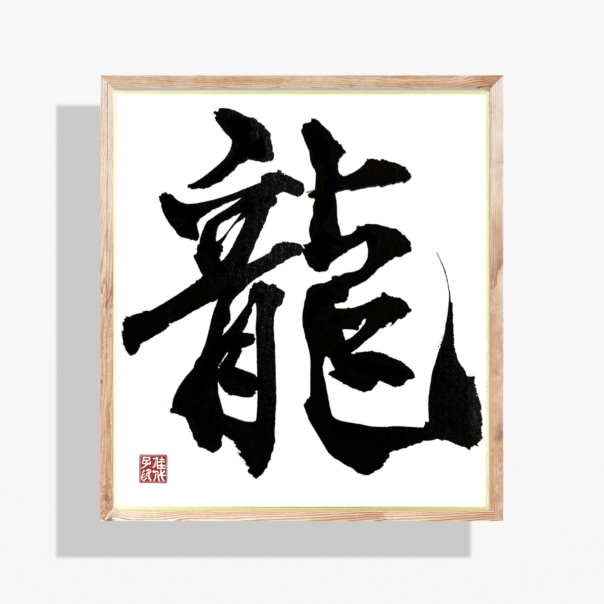 Framed black Japanese calligraphy on a white background. The Kanji means Dragon.